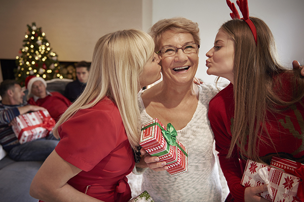  figlie che baciano la mamma con un regalo di natale